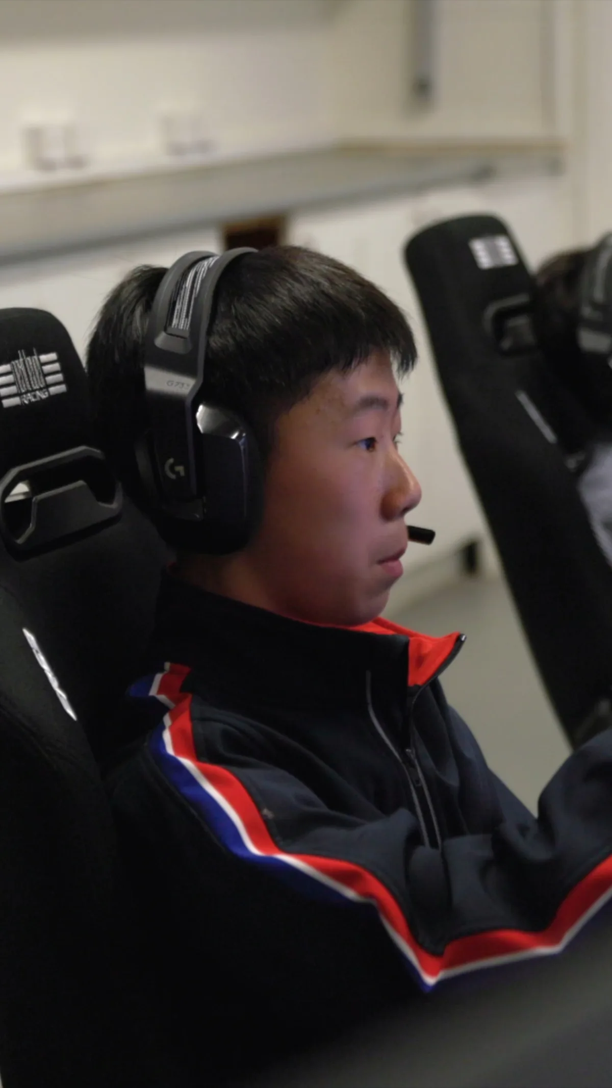 The BGS Plus Sim Racing reel: a student in a headset at the racing simulator