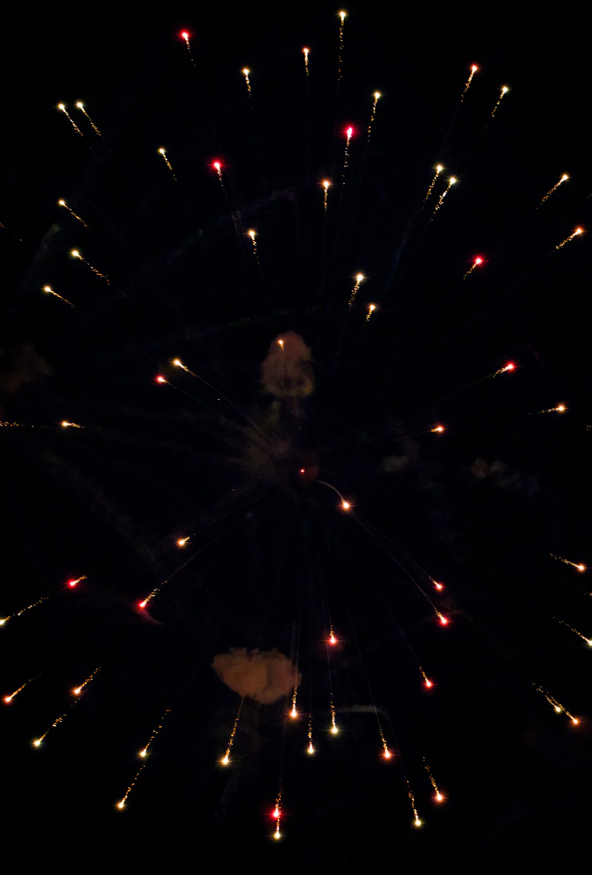 A faint ring of red and gold sparks against black.