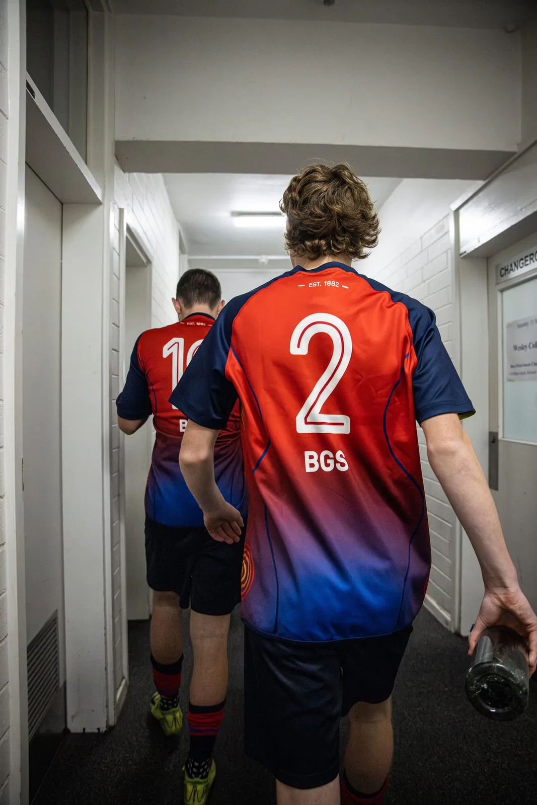 A Brighton Grammar player in the number 2 shirt walks down the corridor towards the pitch.