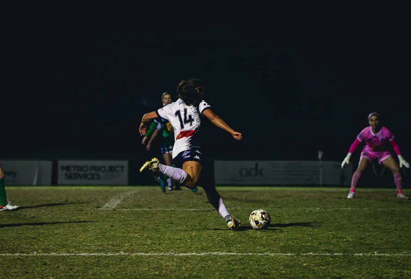 A Calder United player shaping to shoot under lights, the goalkeeper set