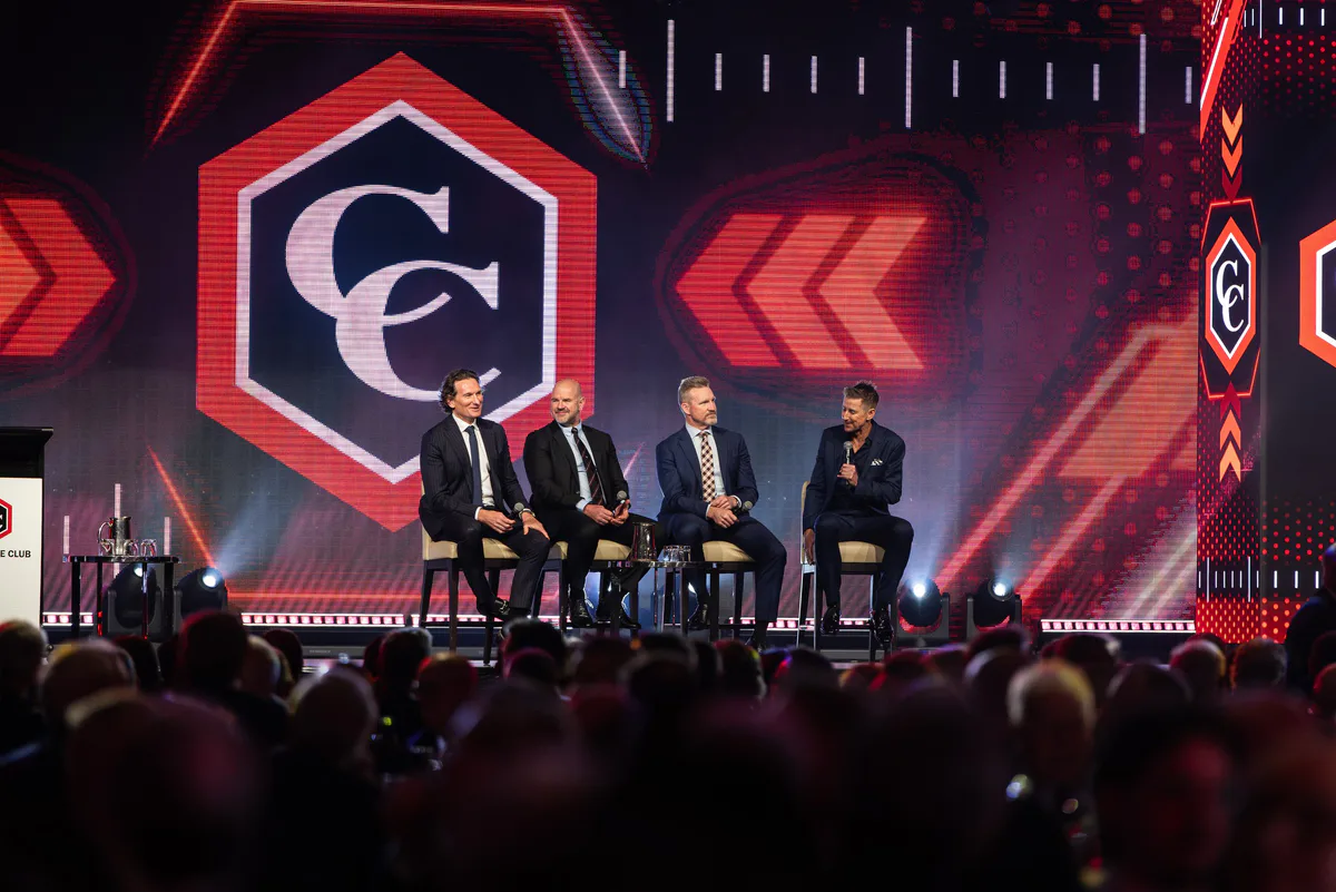 A four-person panel seated on stage under the Carbine Club mark