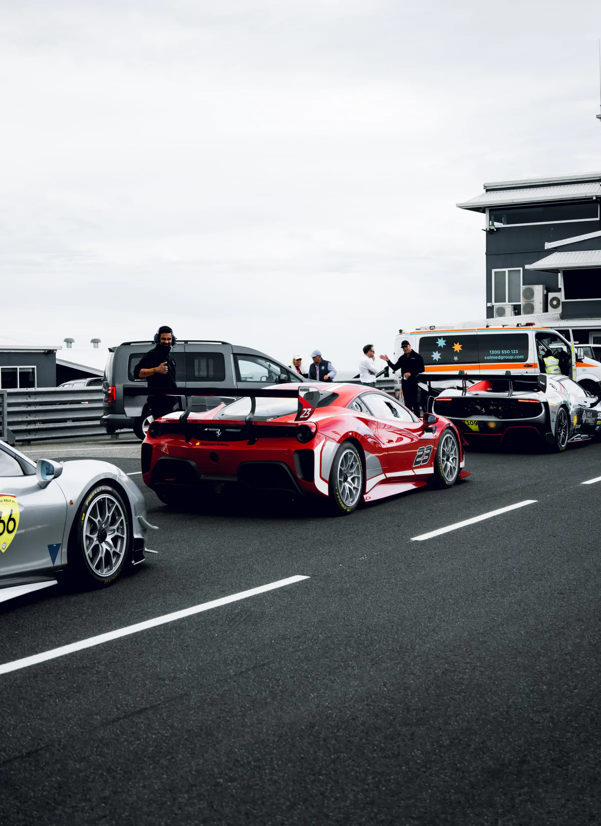 Ferrari Challenge cars lined up in pit lane, crew and officials behind