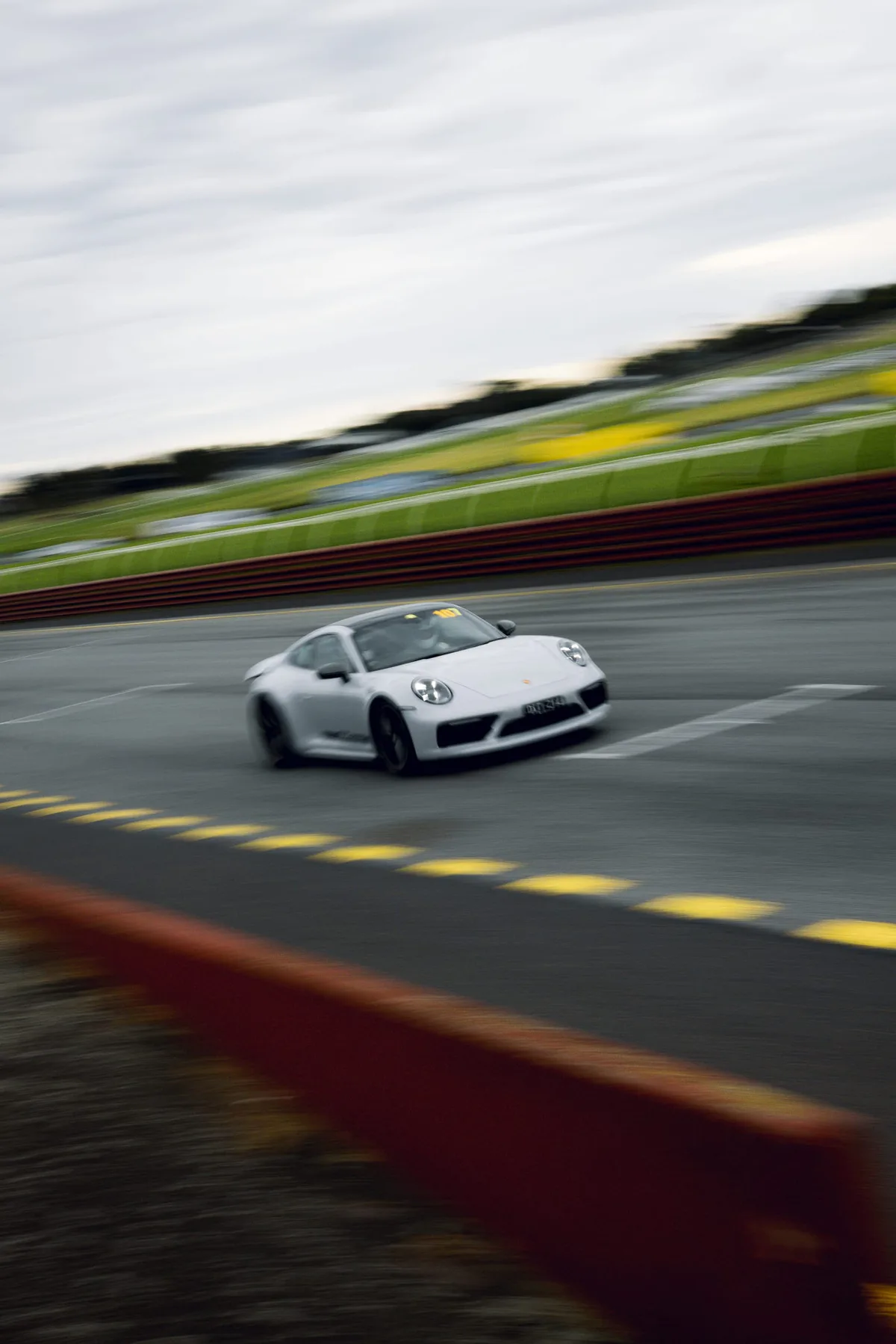 A silver Porsche through a corner, panned.