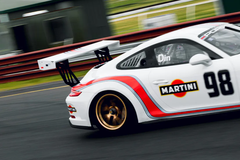 A white Martini-liveried Porsche 911 GT3 Cup car, number 98, panned at speed