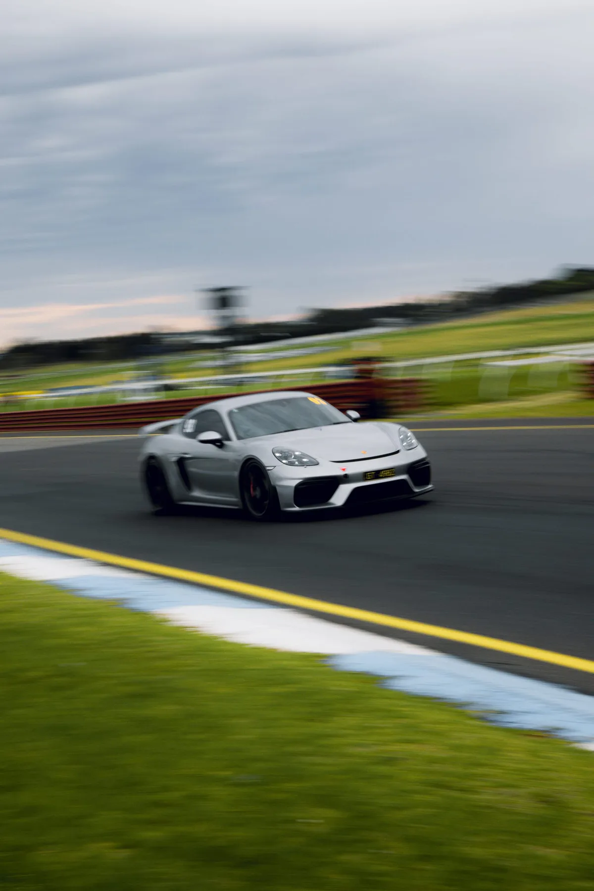A silver Porsche on the track, panned.