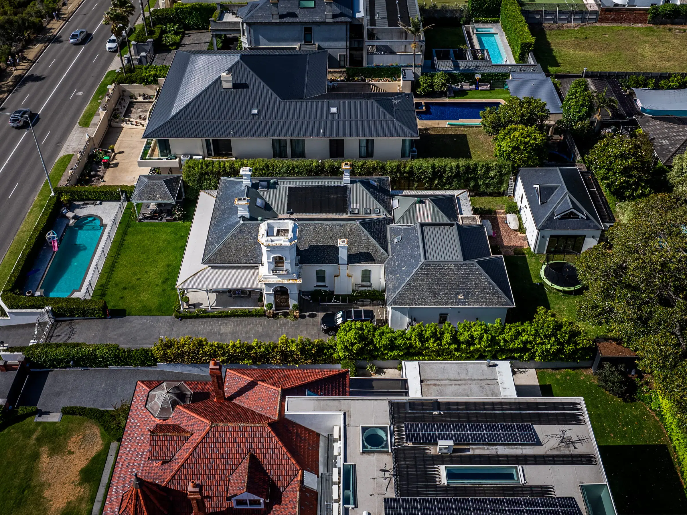 Overhead aerial of large family homes with pools and gardens