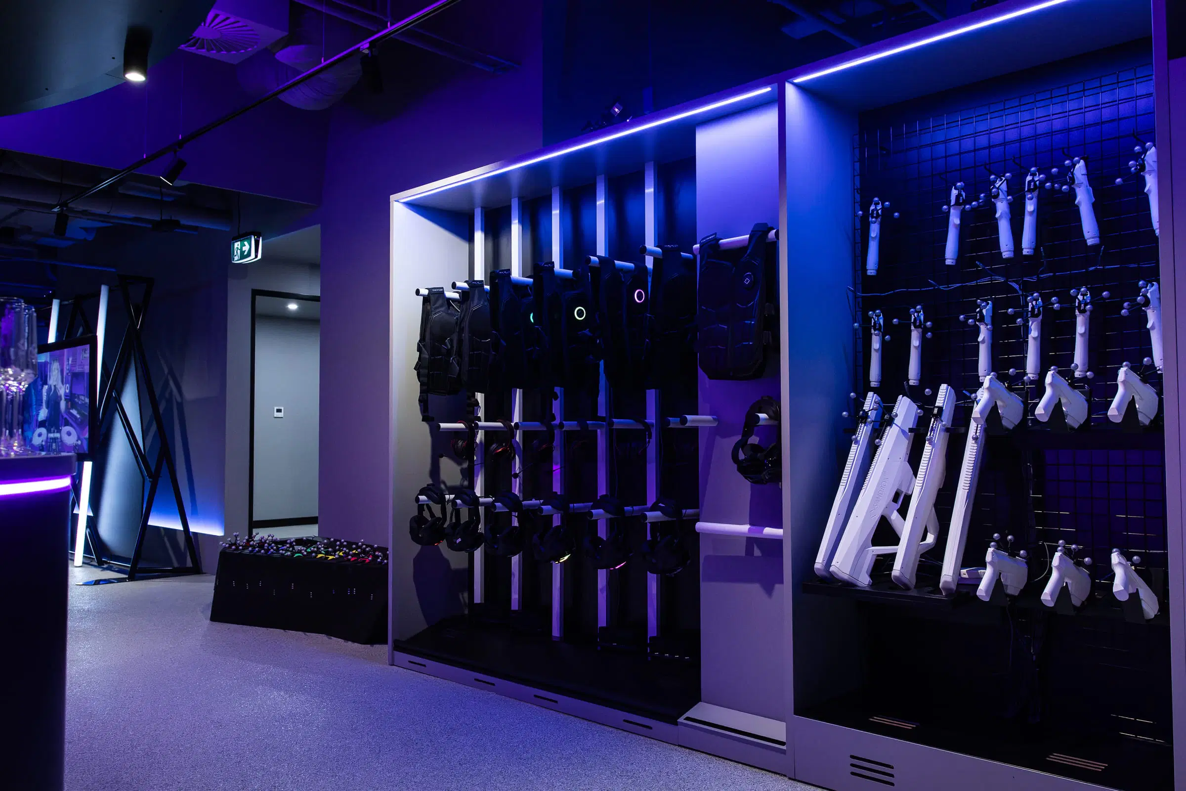 A wall of equipment racks glowing blue in the Sandbox VR Melbourne gear room
