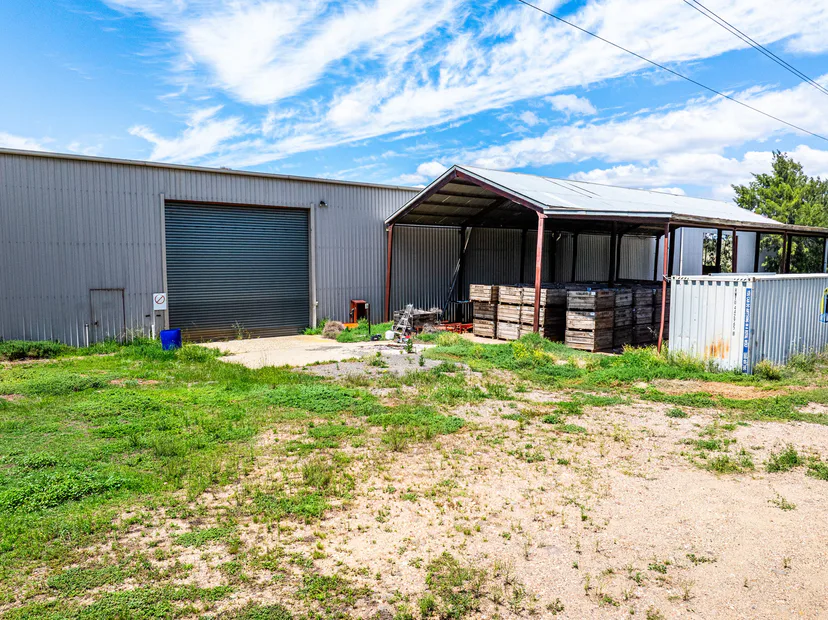A steel farm shed with a roller door and a covered open bay