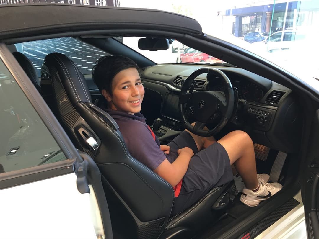 Young Gabe in the driver's seat of a Maserati