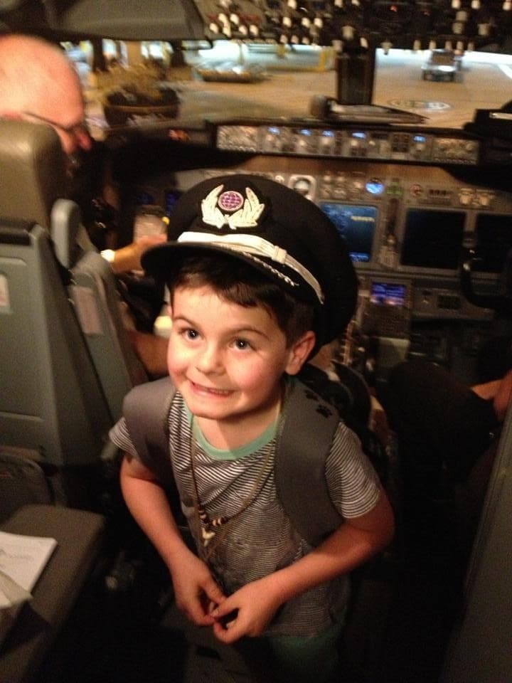 Young Jack in a plane cockpit wearing a pilot's cap