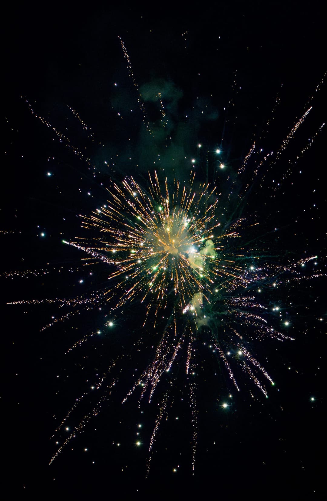 A gold burst with long trailing sparks against black