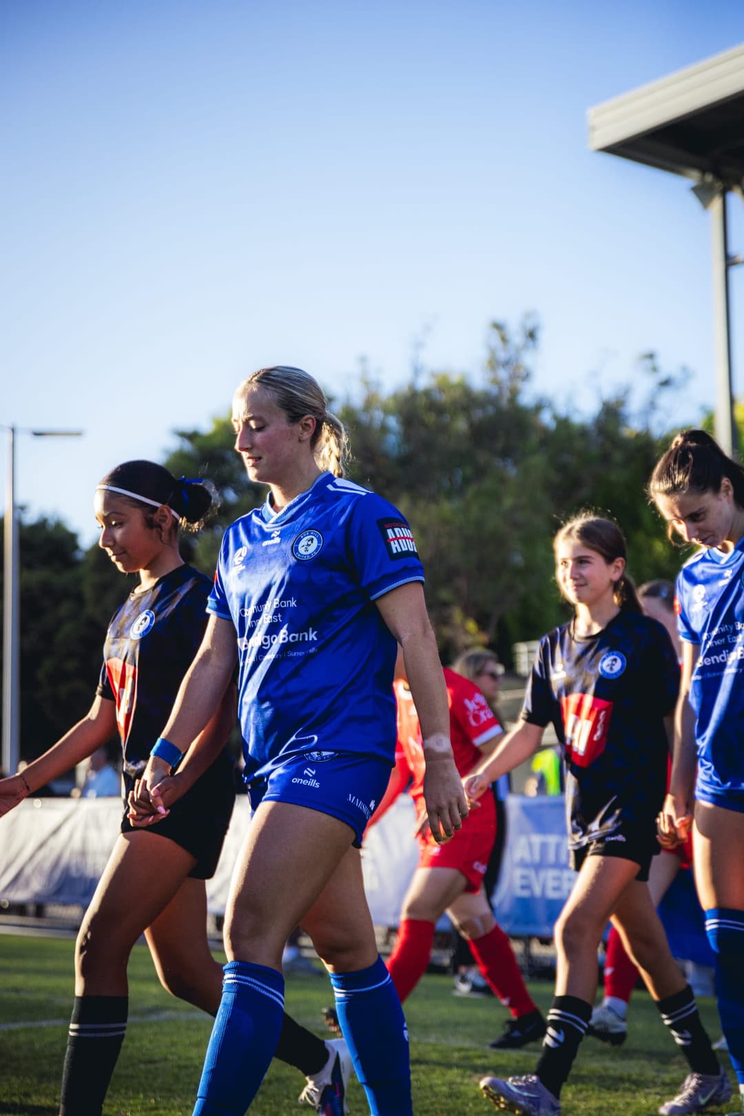 Box Hill United players walking out with junior mascots before kick-off. Frame 8 of 12. Open it