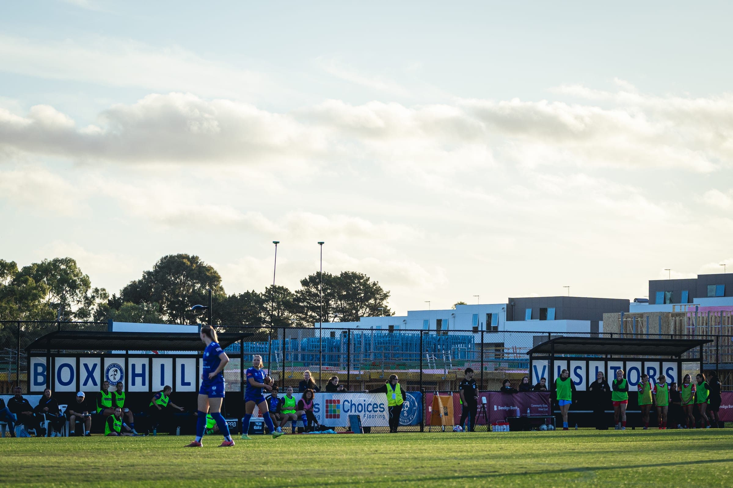 Wide view across the pitch to the Box Hill United and Visitors benches