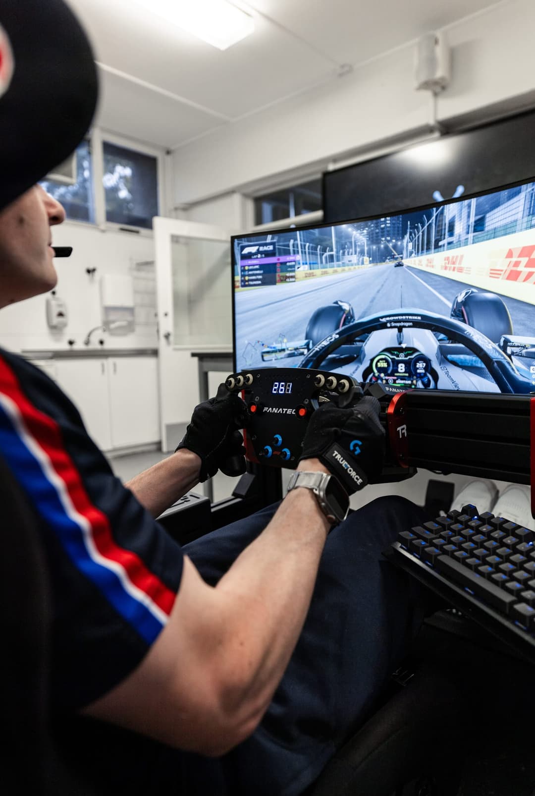 A student at a racing simulator rig, a night race running on the screen