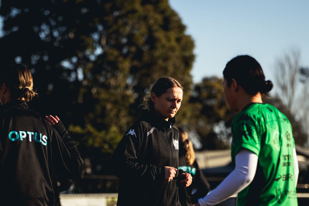 Calder United players and staff talking on the sideline before the warm-up