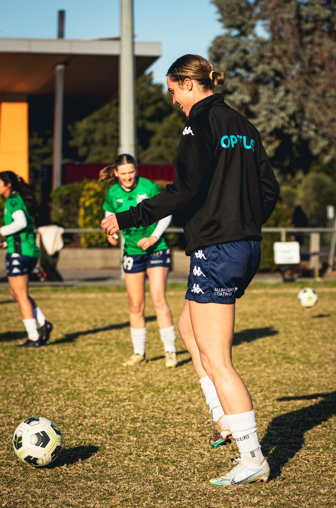 A Calder United player laughing during the warm-up, teammates behind. Frame 1 of 12. Open it
