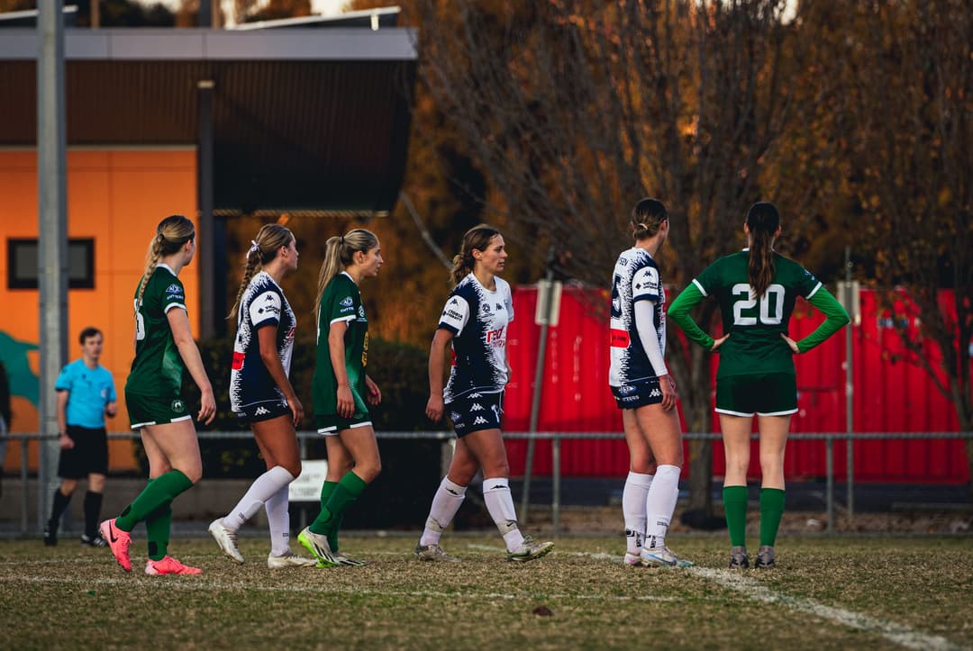 Players from both sides walking into position for a set piece, referee behind. Frame 5 of 12. Open it