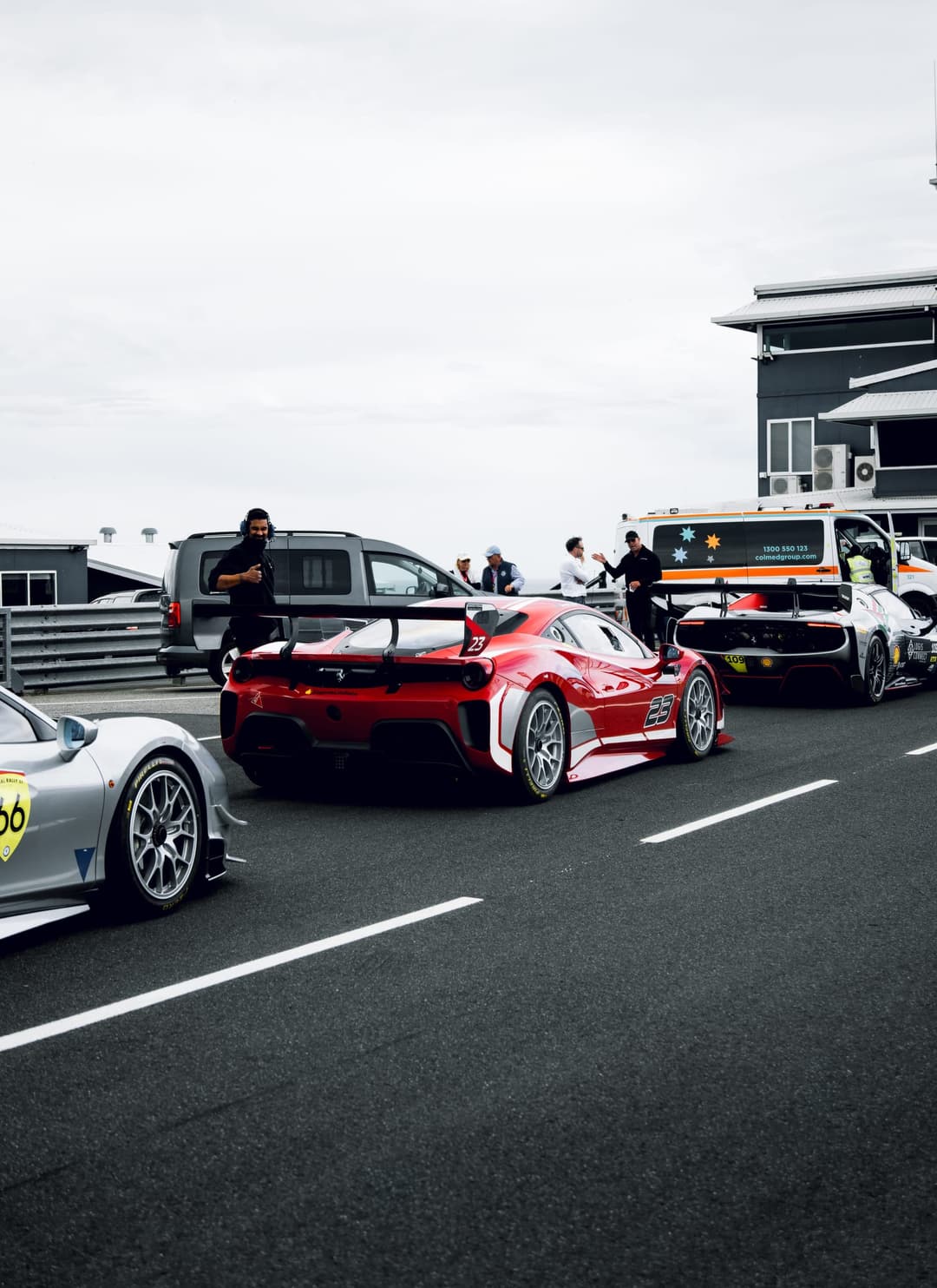 Ferrari Challenge cars lined up in pit lane, crew and officials behind