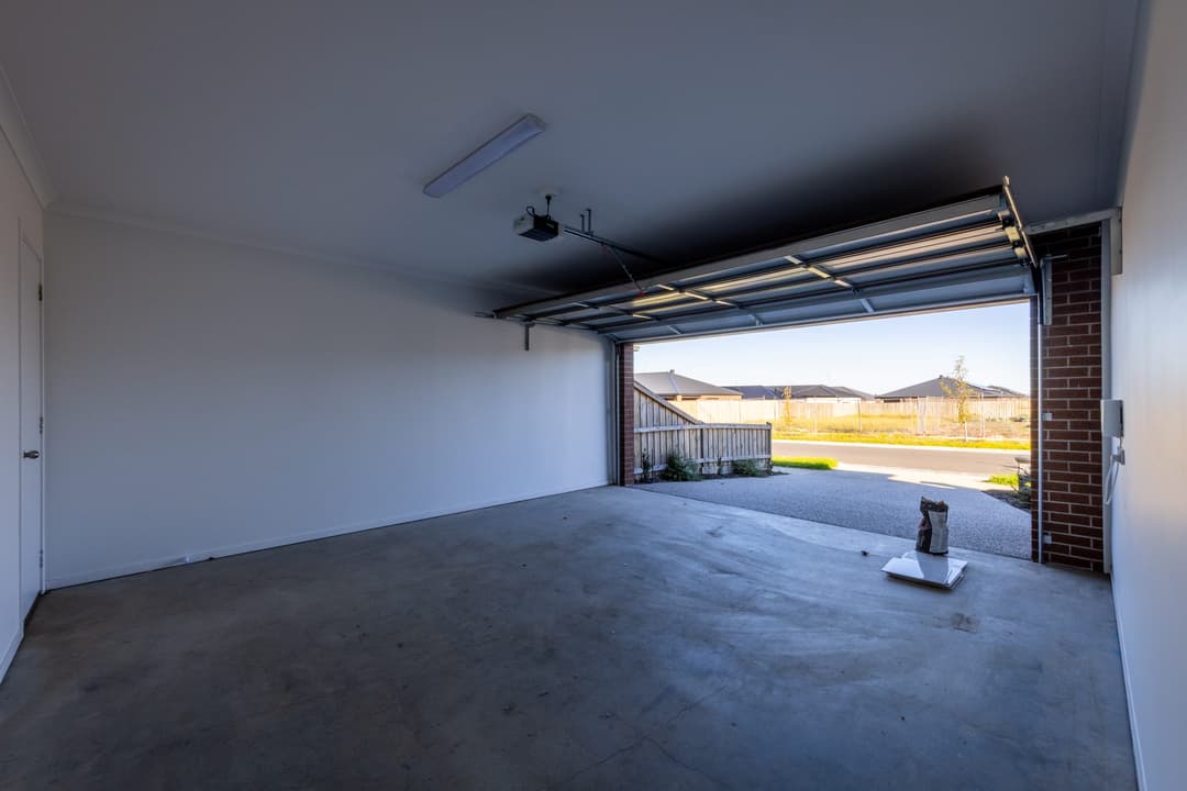 An empty garage in a new home, looking out to the driveway