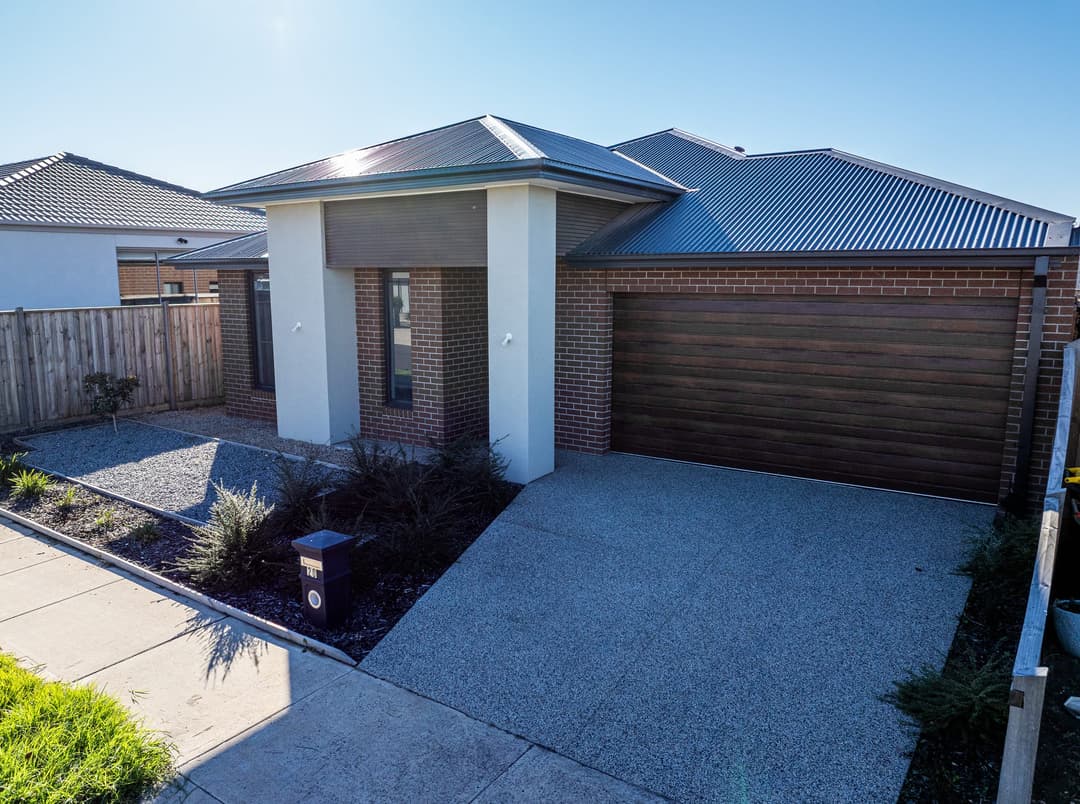 The front of a new brick home, driveway and garage