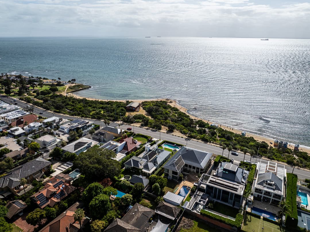 Coastal drone view over bayside homes and the beach