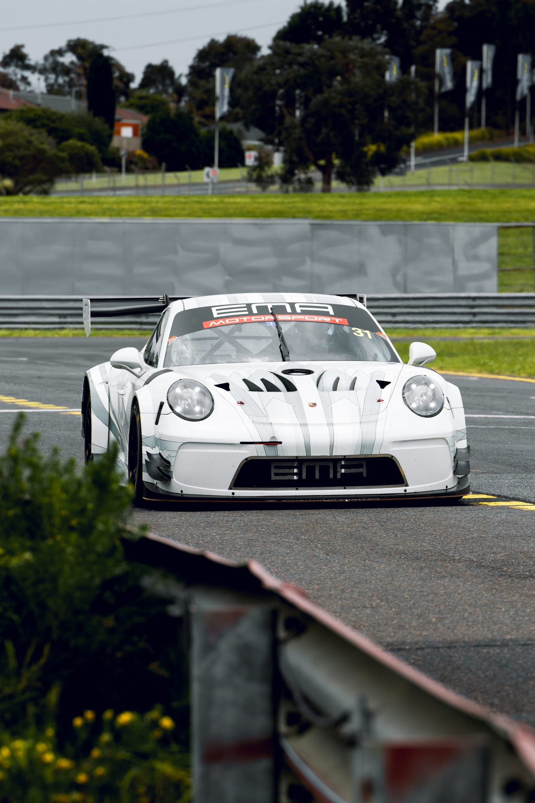 A white Porsche 911 GT3 Cup car, number 31, coming through a corner head-on
