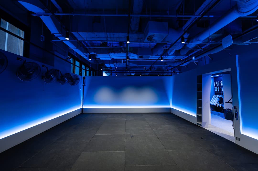 An empty game room lit blue along the floor