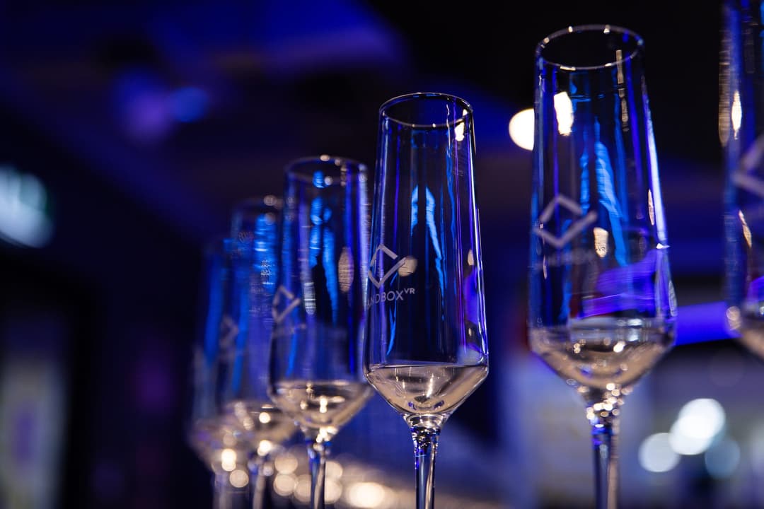 Champagne flutes lined up under blue light