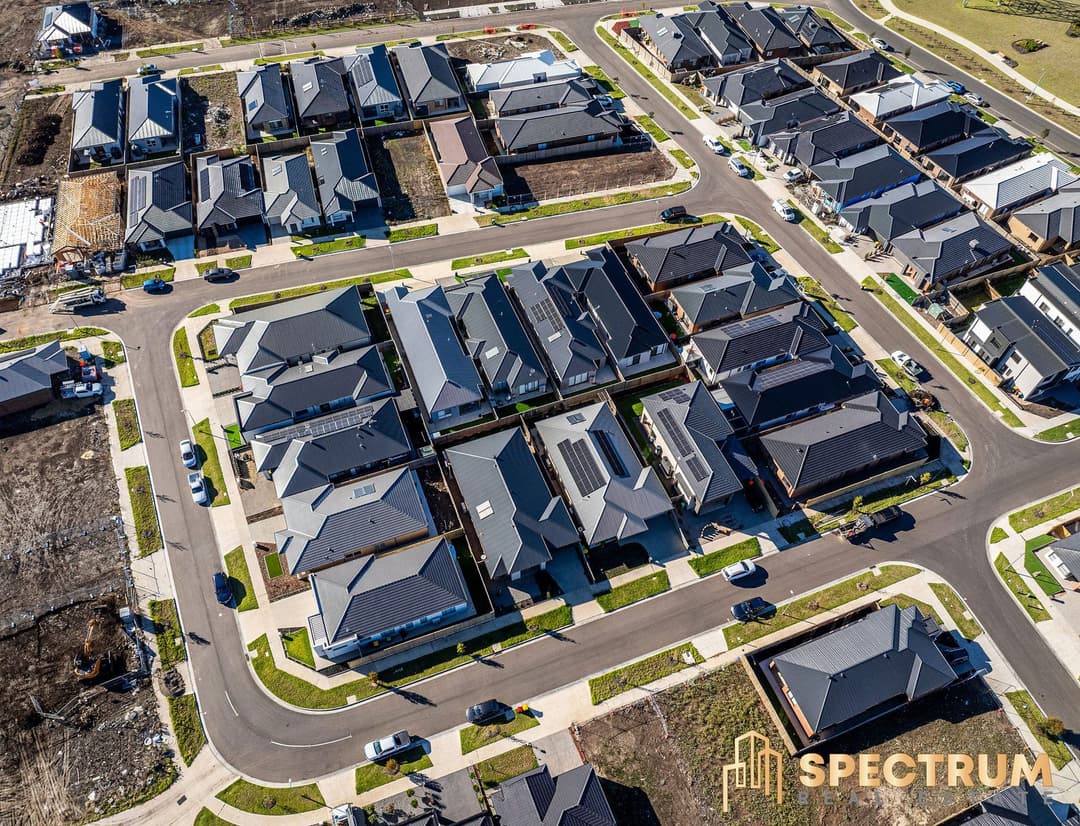 Drone view over a new housing estate, a block of new homes and the streets around it
