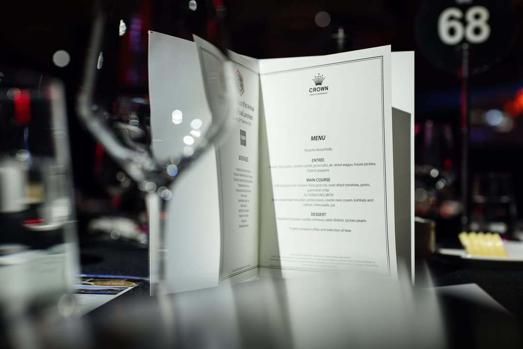 A Crown lunch menu on the table, table number 68 behind it