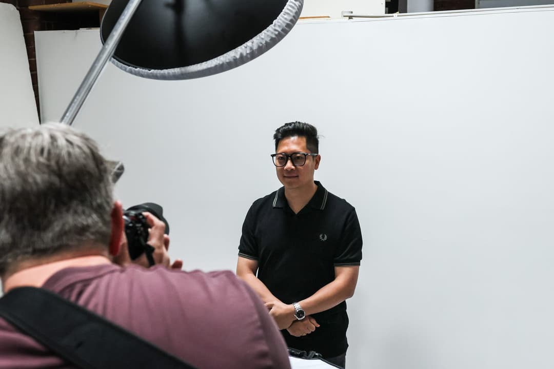 The photographer shoots a client on the white cyclorama.