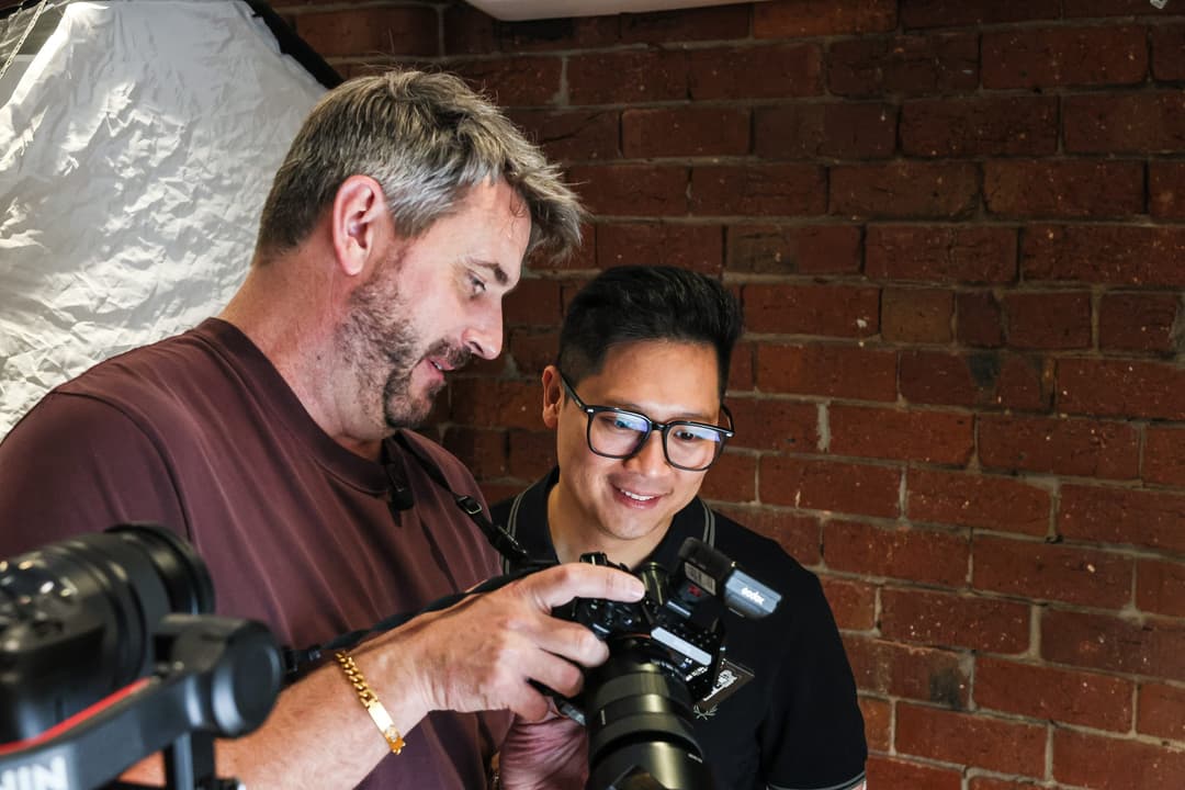 The photographer shows a client the back of the camera.