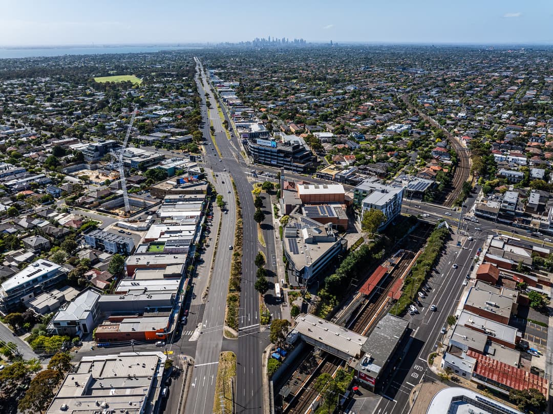 A drone shot down the highway into the Melbourne CBD skyline